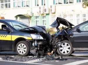 A collision involving crashed automobiles on a city road.