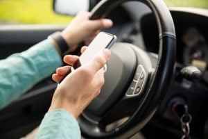 Rideshare accident cases Driver using smartphone while operating vehicle, highlighting a common cause of rideshare accidents.